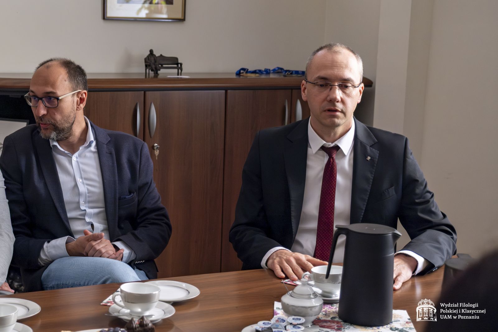Rozmowy przy stole w gabinecie dziekańskim.