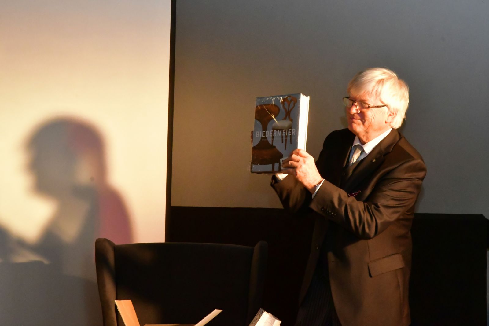 Prof. Zieliński prezentuje otrzymaną książkę o biedermeierze.