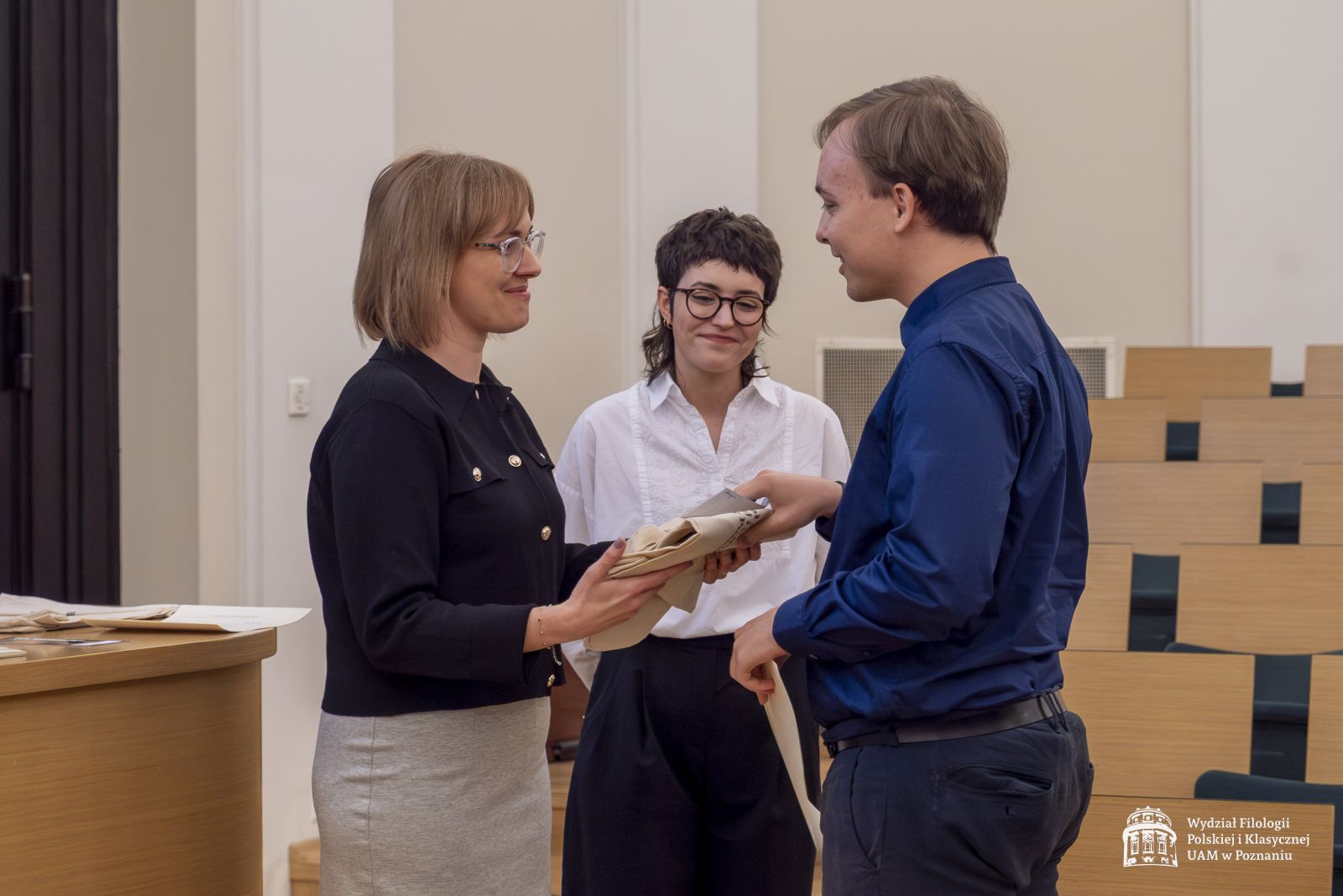 Dwie członkinie jury wręczają nagrody studentowi.