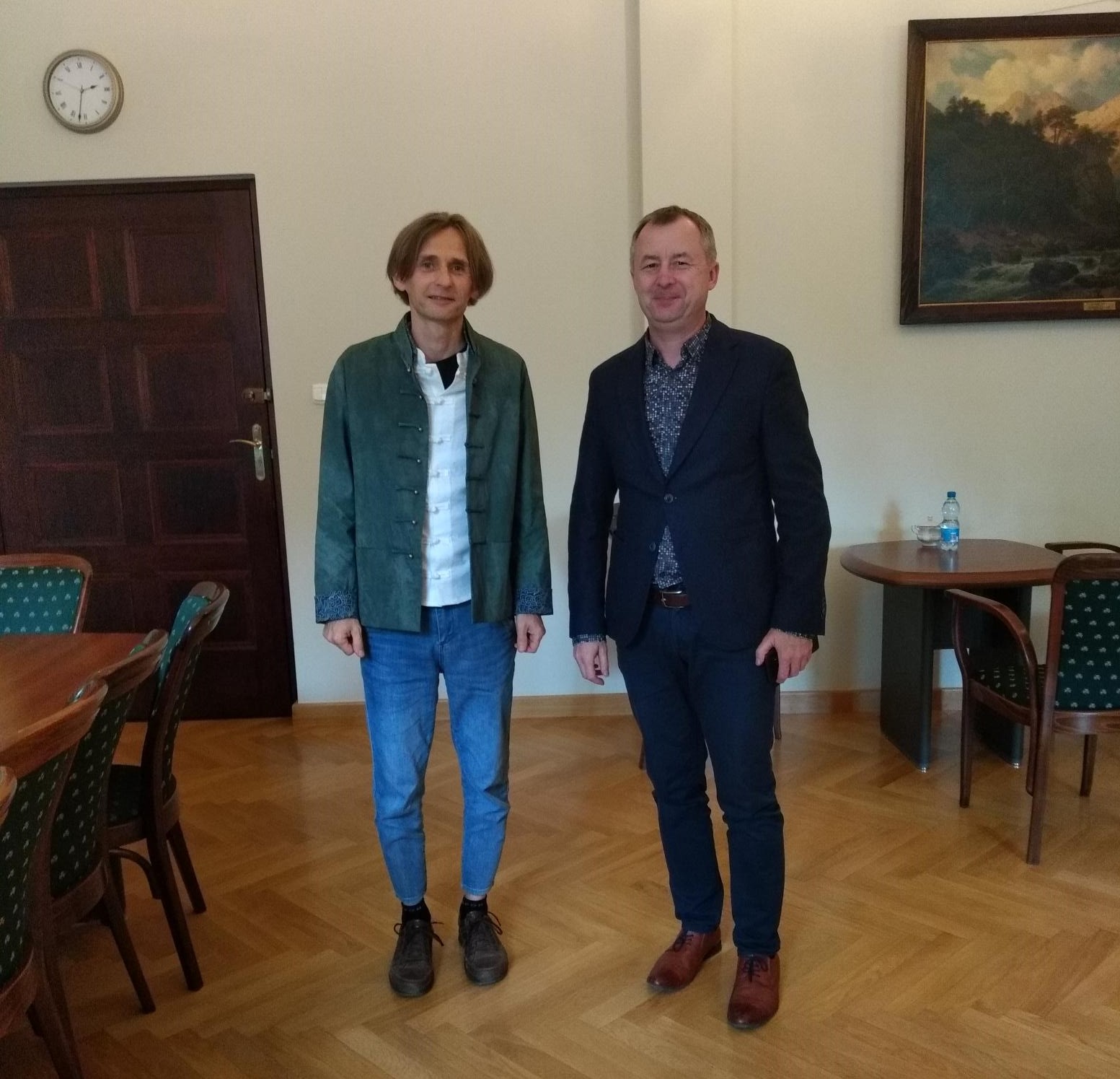 Dziekan WFPiK prof. Tomasz Mizerkiewicz i dr Paweł Zacharewicz stoją obok siebie w gabinecie dziekańskim, uśmiechają się do aparatu.