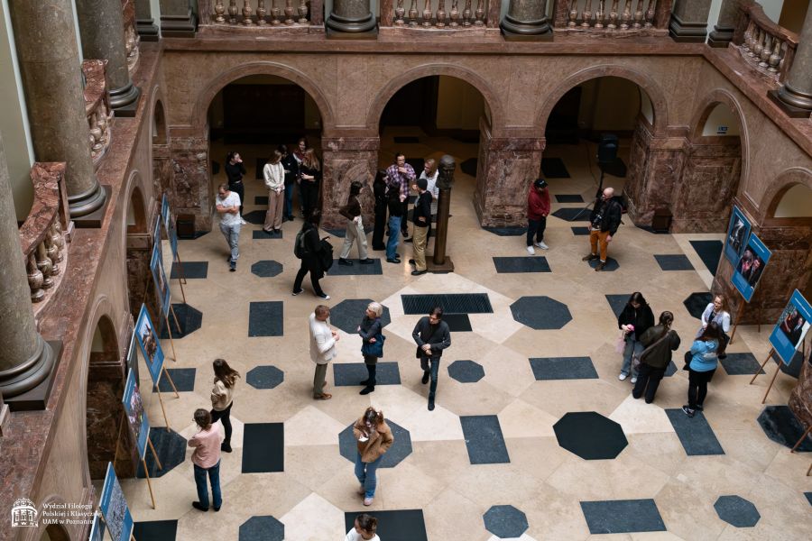 Widok holu głównego z górnej galerii, kilkanaście osób przechadza się pomiędzy tablicami z wystawą o Vaclavie Havlu.