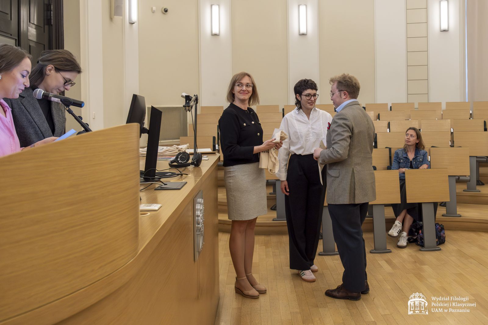 Dwie członkinie jury wręczają nagrody studentowi.