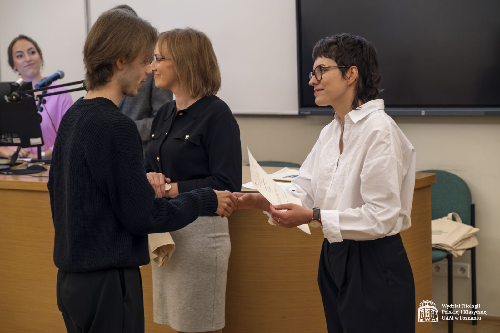 Dwie członkinie jury wręczają nagrody studentowi.
