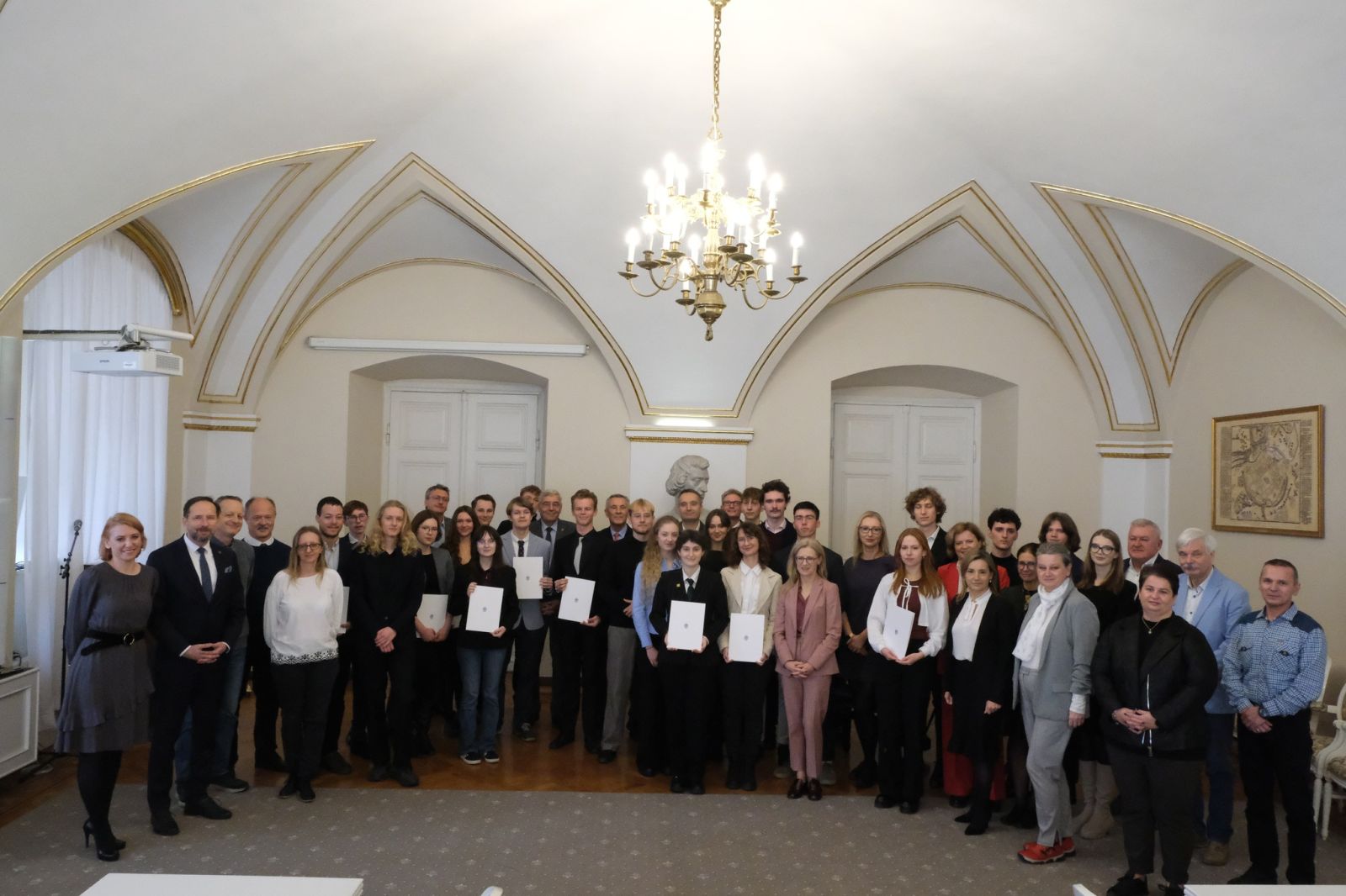 Laureaci stypendiów, ich opiekunowie i przedstawiciele władz miasta i władz uczelni pozują do wspólnego zdjęcia w Sali Białej Urzędu Miasta Poznania.