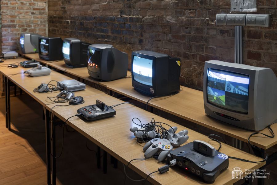 Rząd monitorów z podpiętymi różnego rodzaju konsolami retro.