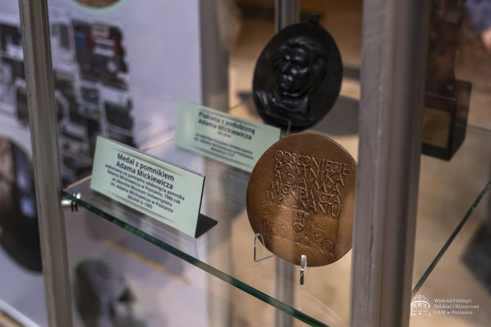 W szklanej gablocie wystawione medale pamiątkowe z pomnikiem Mickiewicza.