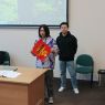 Dwaj studenci z Chin wygłaszają prezentację o chińskim Nowym roku, pokazując zebranym tradycyjną czerwoną kopertę.