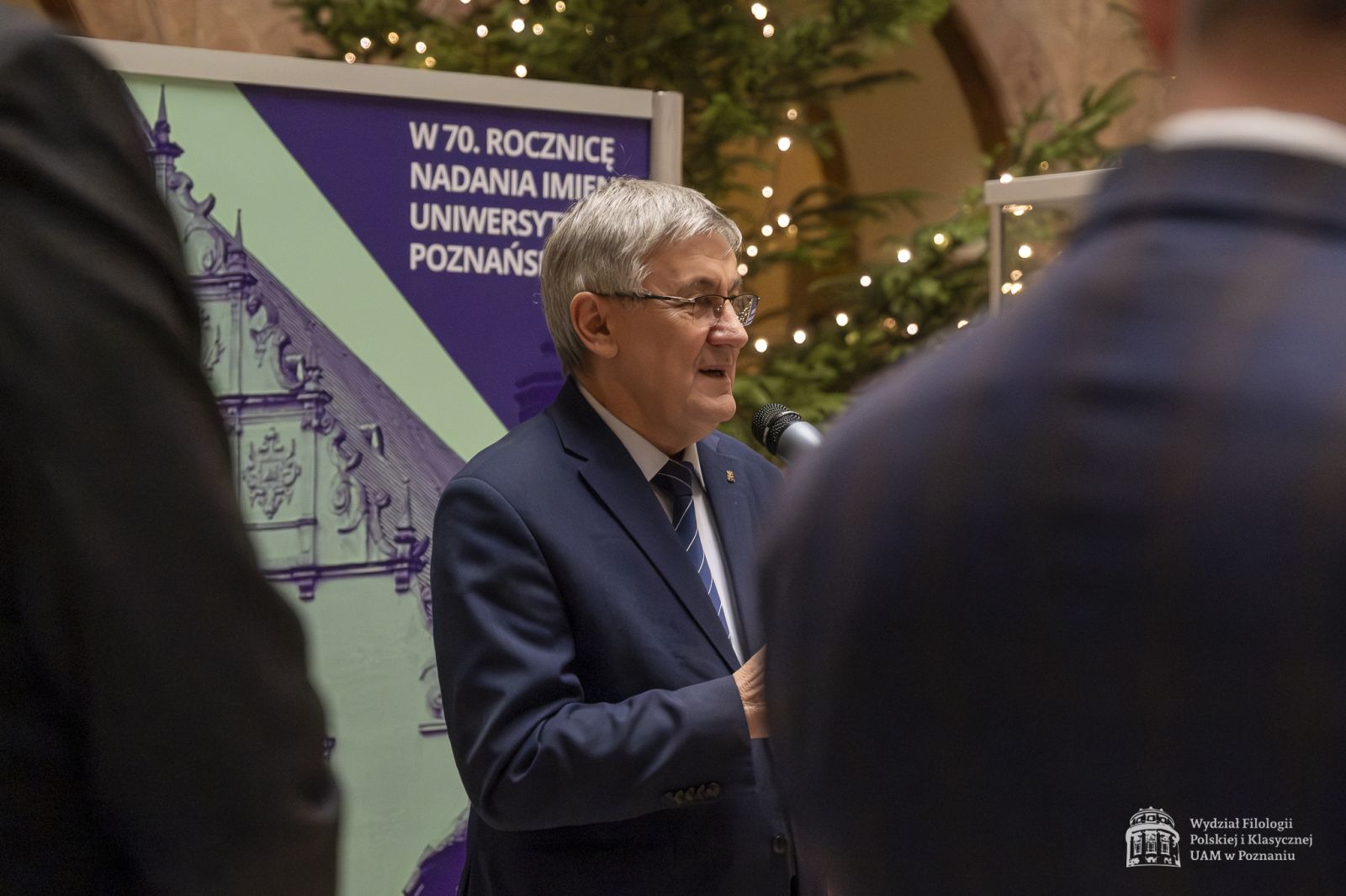 Prof. Wallas przemawiający to mikrofonu w holu Collegium Maius.