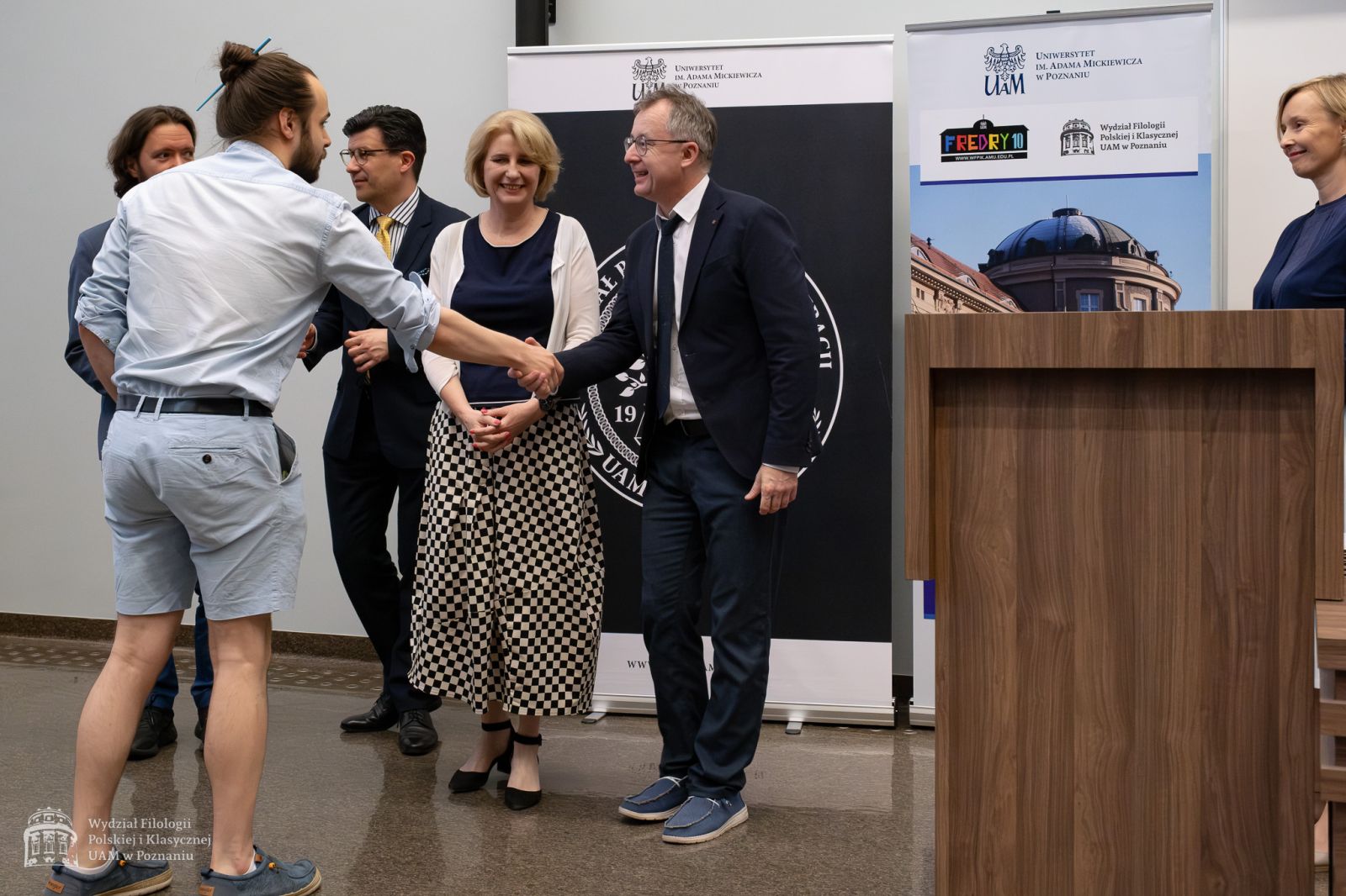 Wręczenie nagrody laureatowi, prof. Tomasz Mizerkiewicz ściska dłoń nagrodzonego.