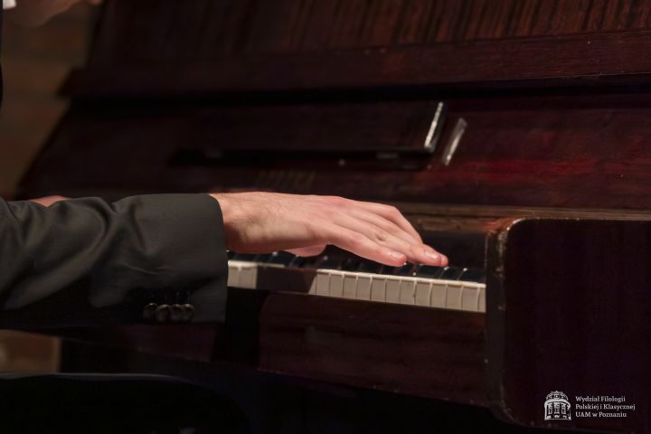 Zbliżenie na dłonie pianisty nad klawiaturą.