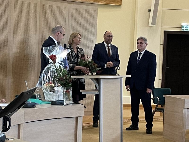 Grono dziekańskie składa gratulacje prof. Sieradzkiemu, wręczając mu bukiet kwiatów.