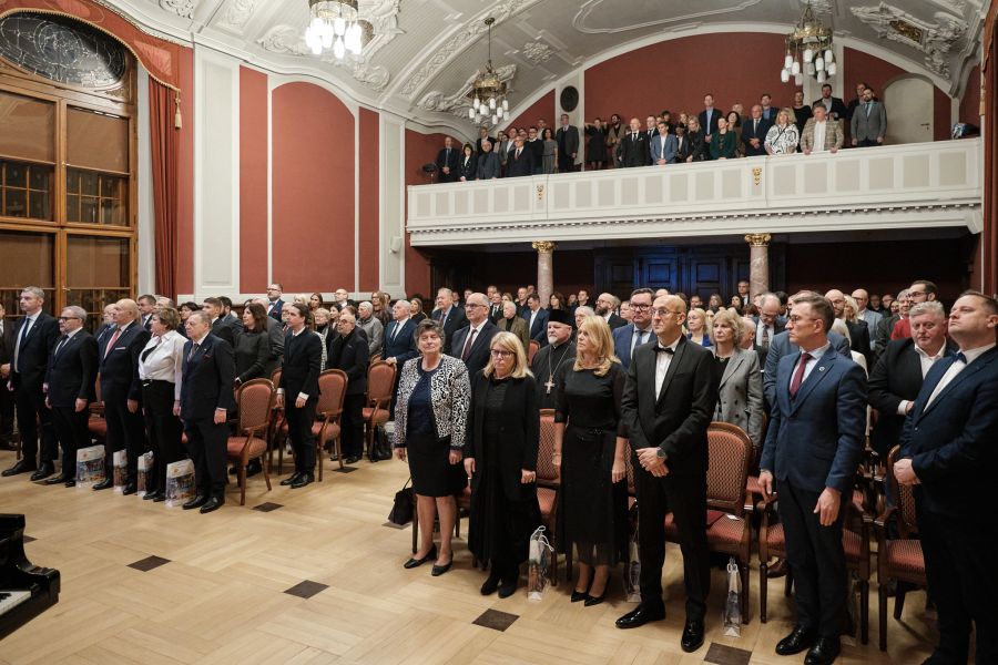 Sala Lubrańskiego w Collegium Minus wypełniona po brzegi publicznością, wszyscy stoją z poważnymi minami.