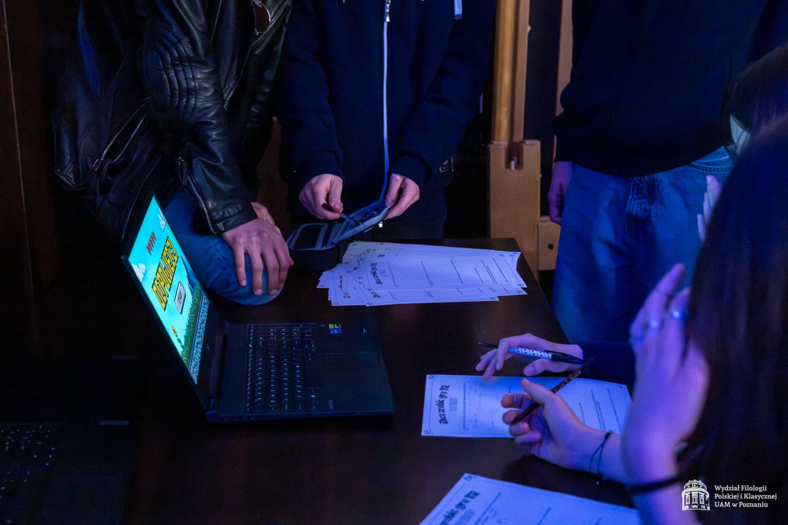 Uczestnicy warsztatów VR pochyleni nad laptopem.