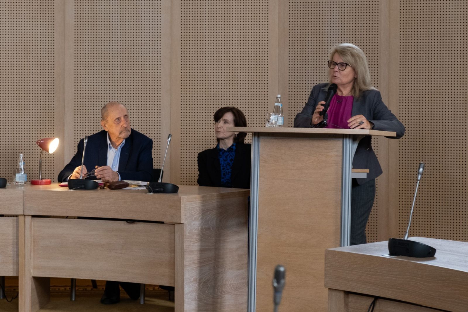 JMR prof. Bogumiła Kaniewska stoi przy mównicy w Salonie Mickiewicza, obok niej siedzą: prof. Edward Balcerzan i prof. Elżbieta Winiecka