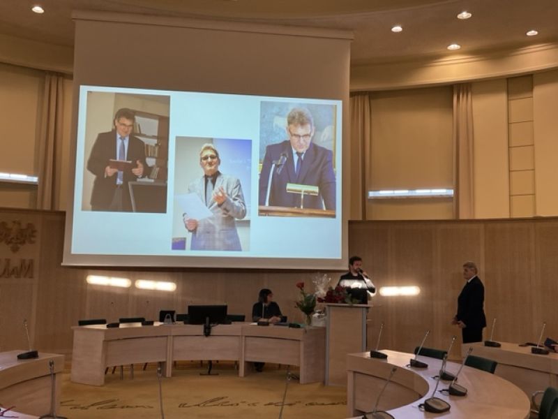 Dyrektor IFS wspomina pracę prof. Sieradzkiego, na ekranie wyświetlają się zdjęcia z różnych lat.