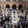 W holu głównym przemawia Prorektor UAM prof. Michał Banaszak. Zdjęcie z góry, pokazujące licznie zgromadzoną publiczność.