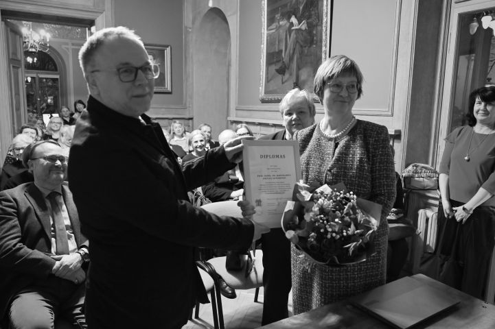 Czarno-białe zdjęcie prof. Okulicz-Kozaryna odbierającego dyplom.