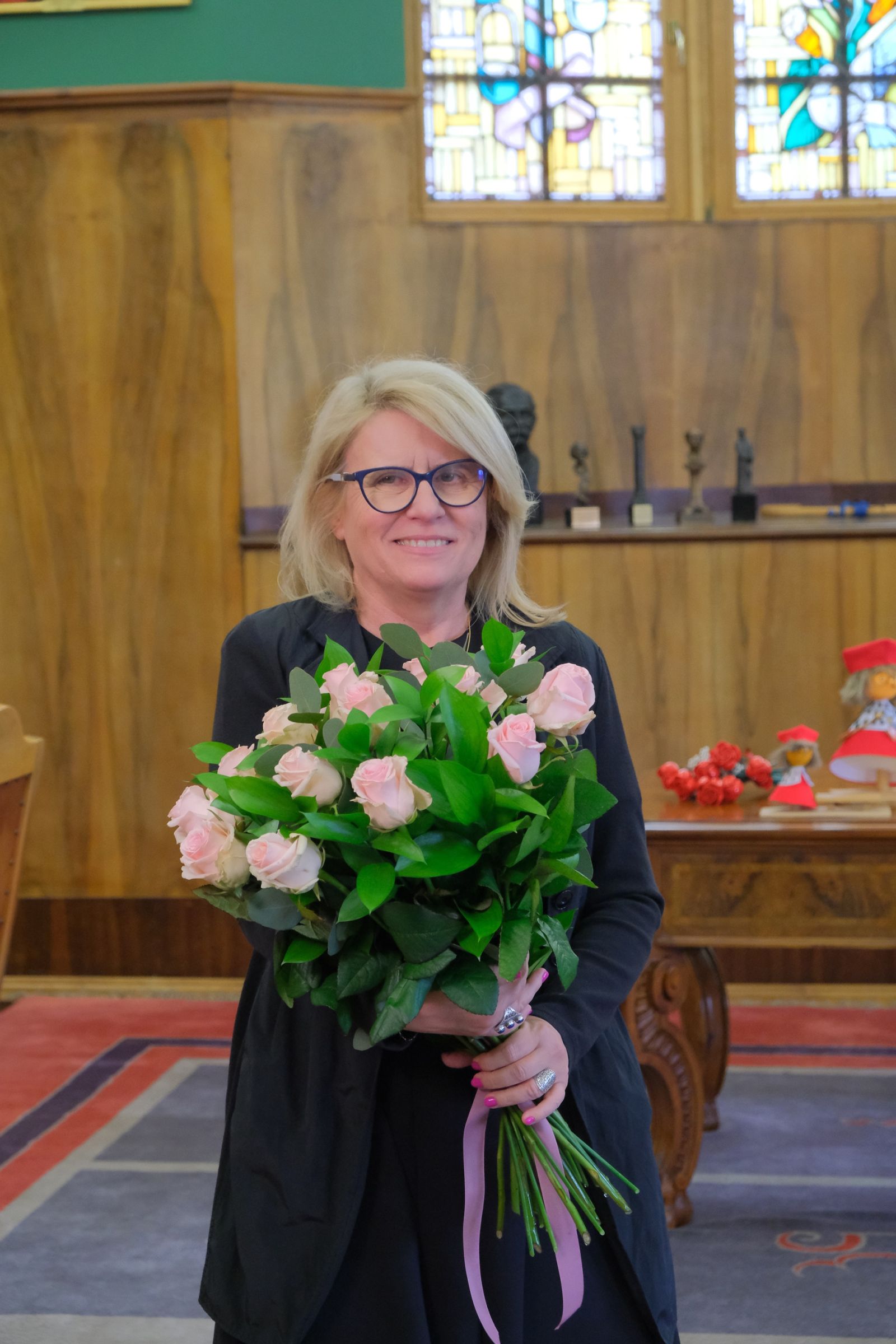 Nowo wybrana Pani Rektor w gabinecie rektorskim z bukietem różowych róż.