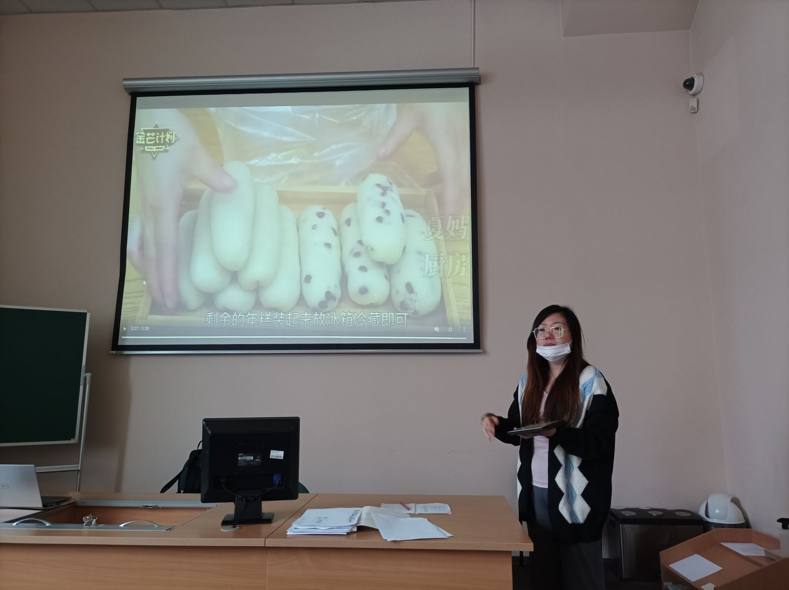Studentka z Chin prezentuje tradycje związane z obchodami chińskiego Nowego Roku. Na rzutniku wyświetla prezentację.