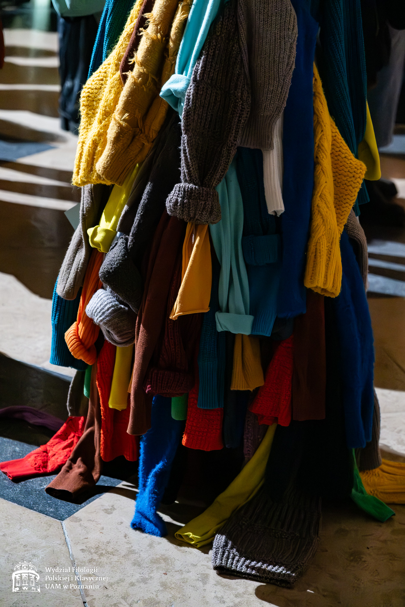 Detal z jednego ze strojów pokazanych na wystawie - dół sukni uszytej z wielu rękawów różnokolorowych dzierganych swetrów.