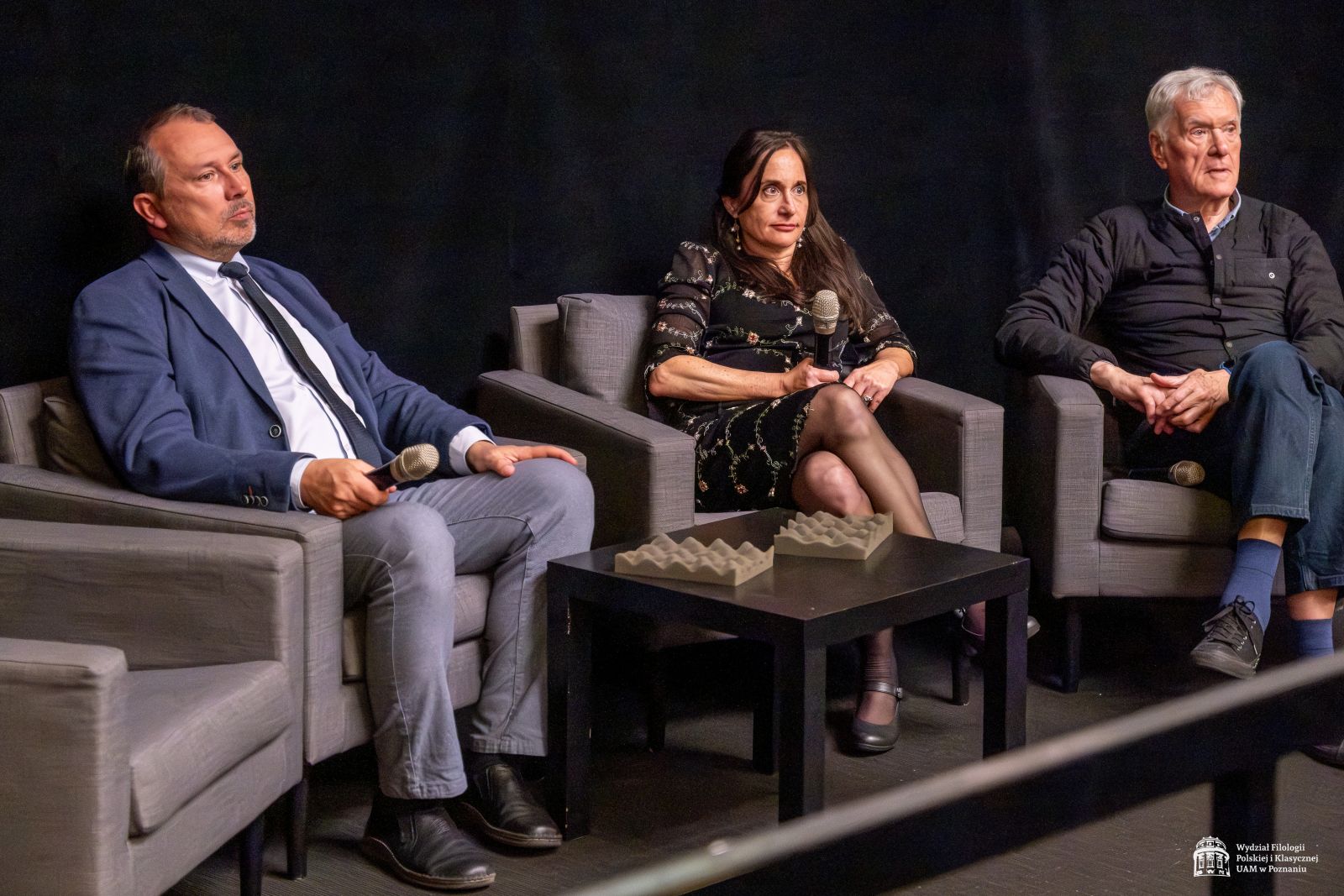 Prof. Jazdon, Laura Morowitz i Piotr Jaxa siedzą w fotelach i słuchają pytania z publiczności.