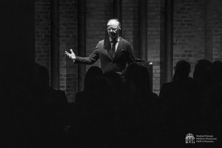 Prorektor Akademii Muzycznej w Poznaniu prof. Mikołaj Rykowski przemawia w Sali Teatralnej, stojąc obok fortepianu, przed nim widać zgromadzoną publikę.