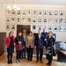 Na fotografii widać grupę 7 osób, za nimi ściana z fotografiami dawnych dziekanów WFPiK.