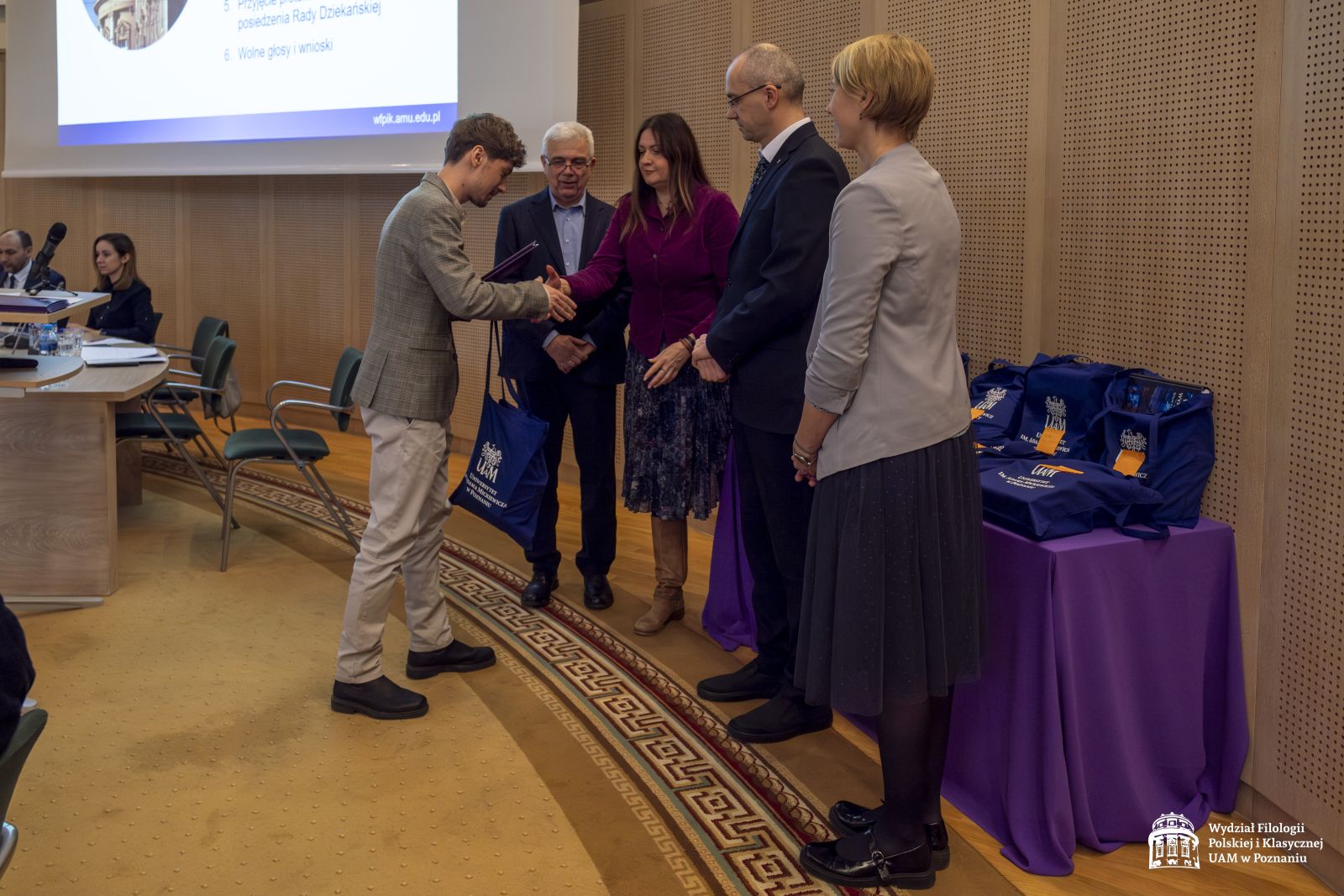 Student odbiera nagrodę w konkursie, przyjmuje gratulacje od przedstawicieli Jury: prof. Jana Galanta i dr Marleny Puk oraz dziekani: prof. Krzysztof Skibski i dr Urszula Kowalska-Nadolna.