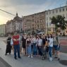 Zdjęcie dużej grupy osób stojącej na chodniku na tle kamienic na poznańskich Jeżycach