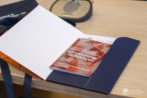 Na stole leży otwarta teczka, a w niej program konferencji.