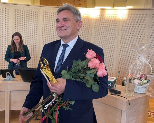 Prof. Sieradzki z kwiatami i prezentami.