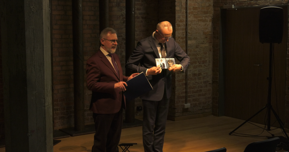 Dziekan WFPiK oraz prof. Piotr Urbański prezentują publiczności płyty gitarzysty Andrzeja Grygiera.
