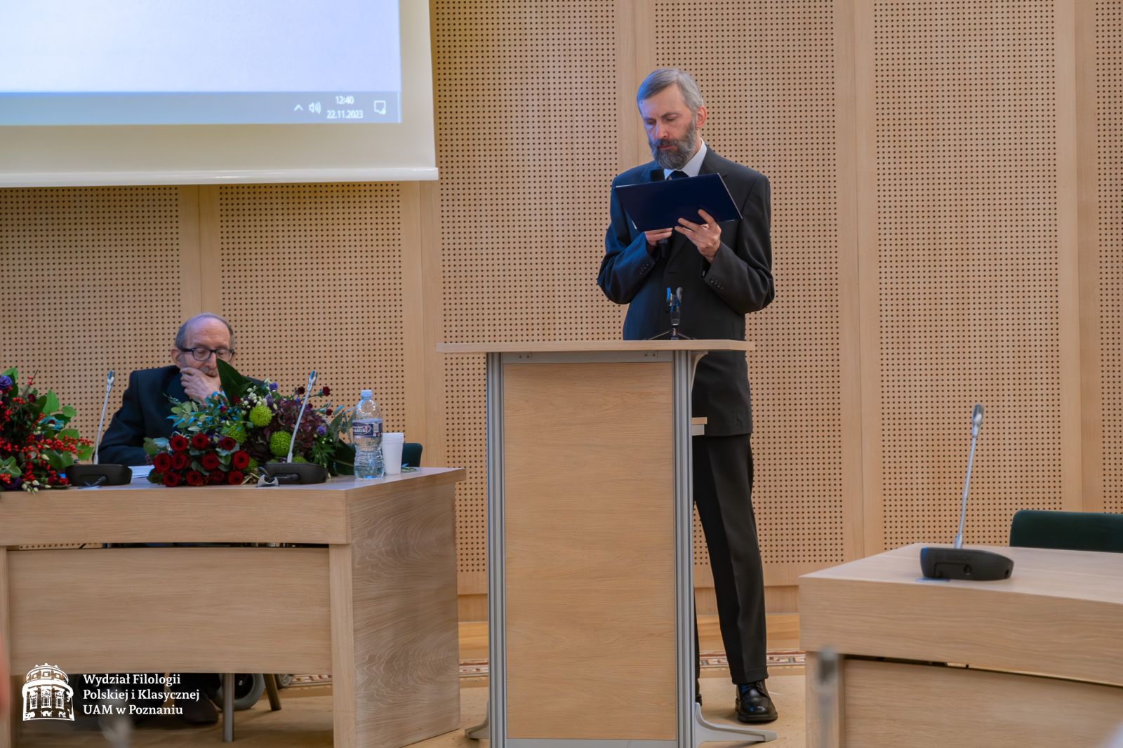 Prof. Marek Wedemann stoi przy mównicy i przemawia do mikrofonu.