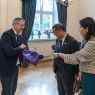 Dziekan WFPiK prezentuje torbę płócienną z logotypem Fredry 10, ogląda ją dwoje członków delegacji z Chin.