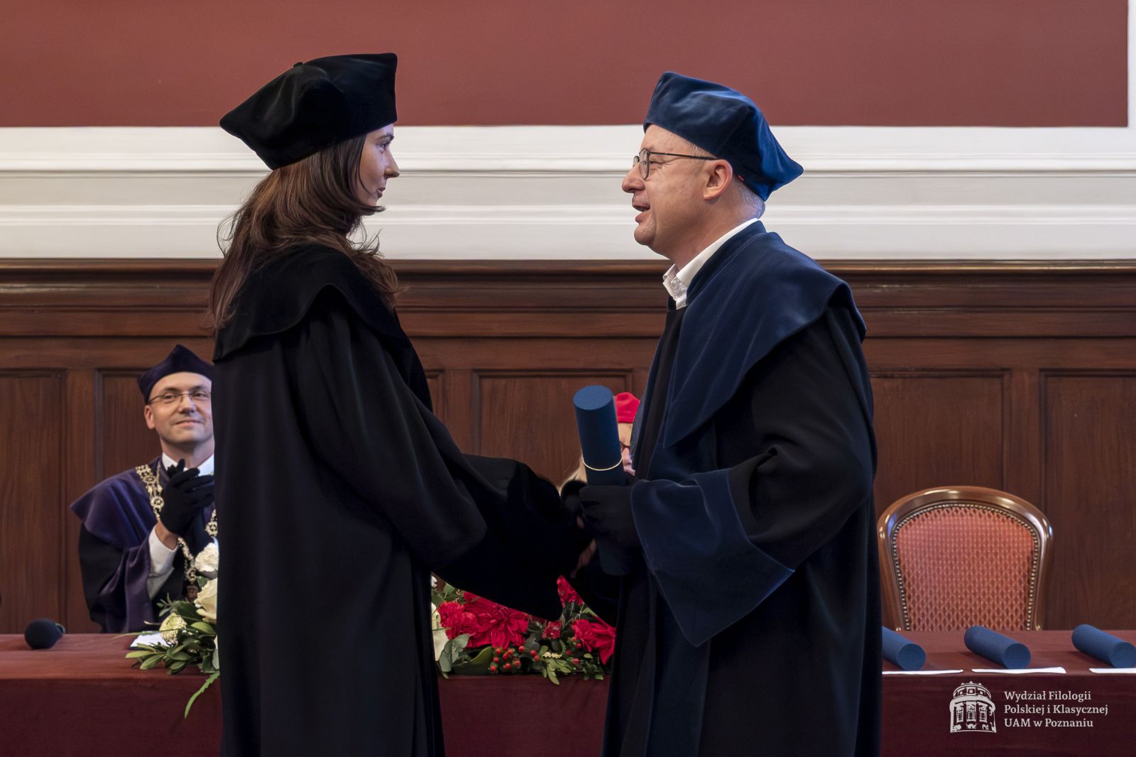 Promotor wręcza doktorantce dyplom.