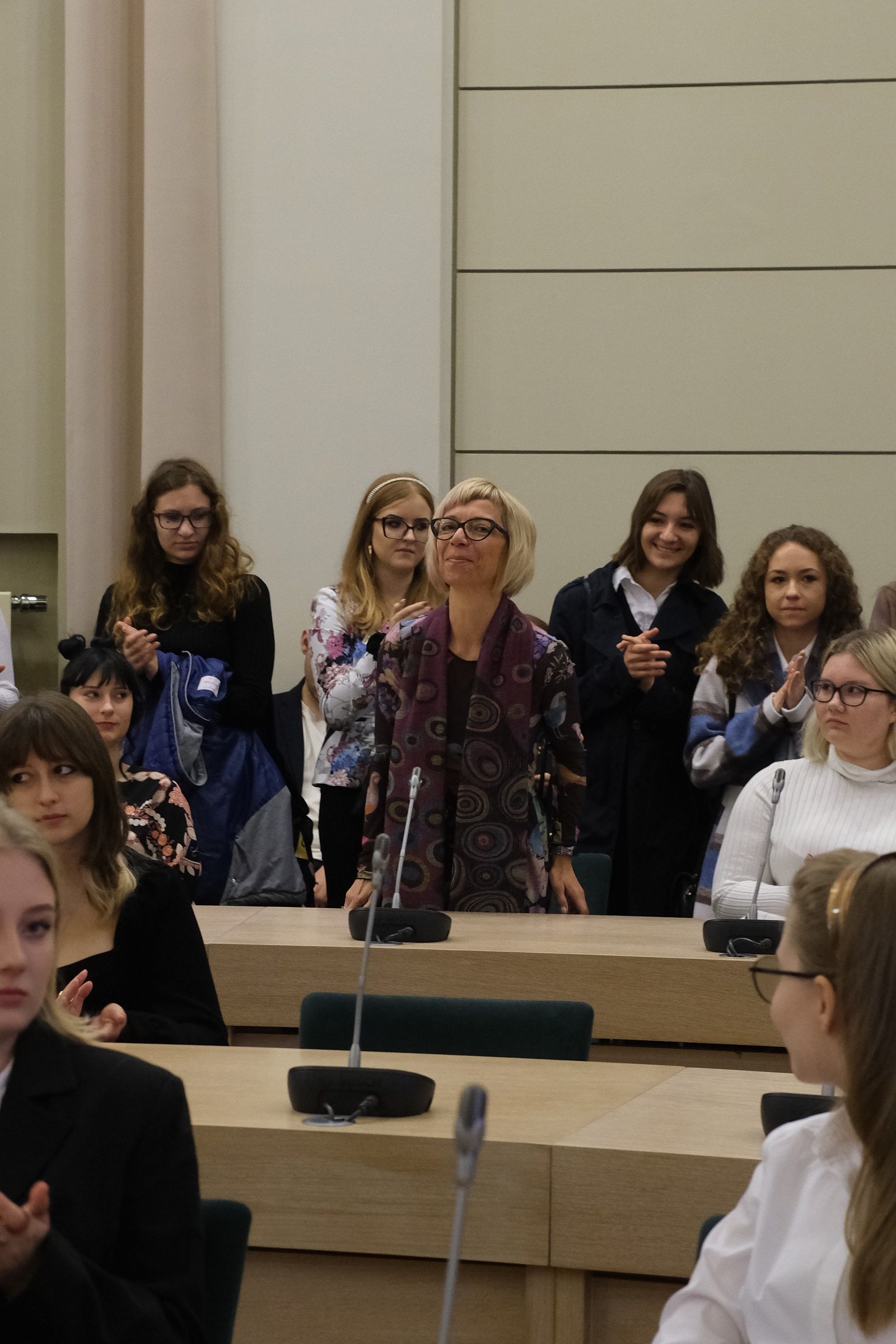 Prof. Izabela Lis-Wielgosz, wicedyrektor Instytut Filologii Słowiańskiej, stoi za stołem w Salonie Mickiewicza, kłania się publiczności.