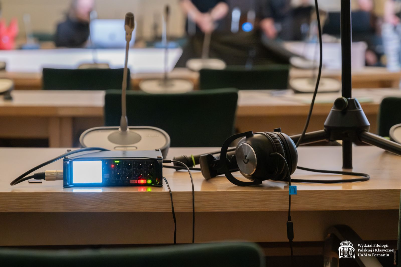 Na stole leży sprzęt do nagrywania audio i wideo, między innymi słuchawki i mikrofon