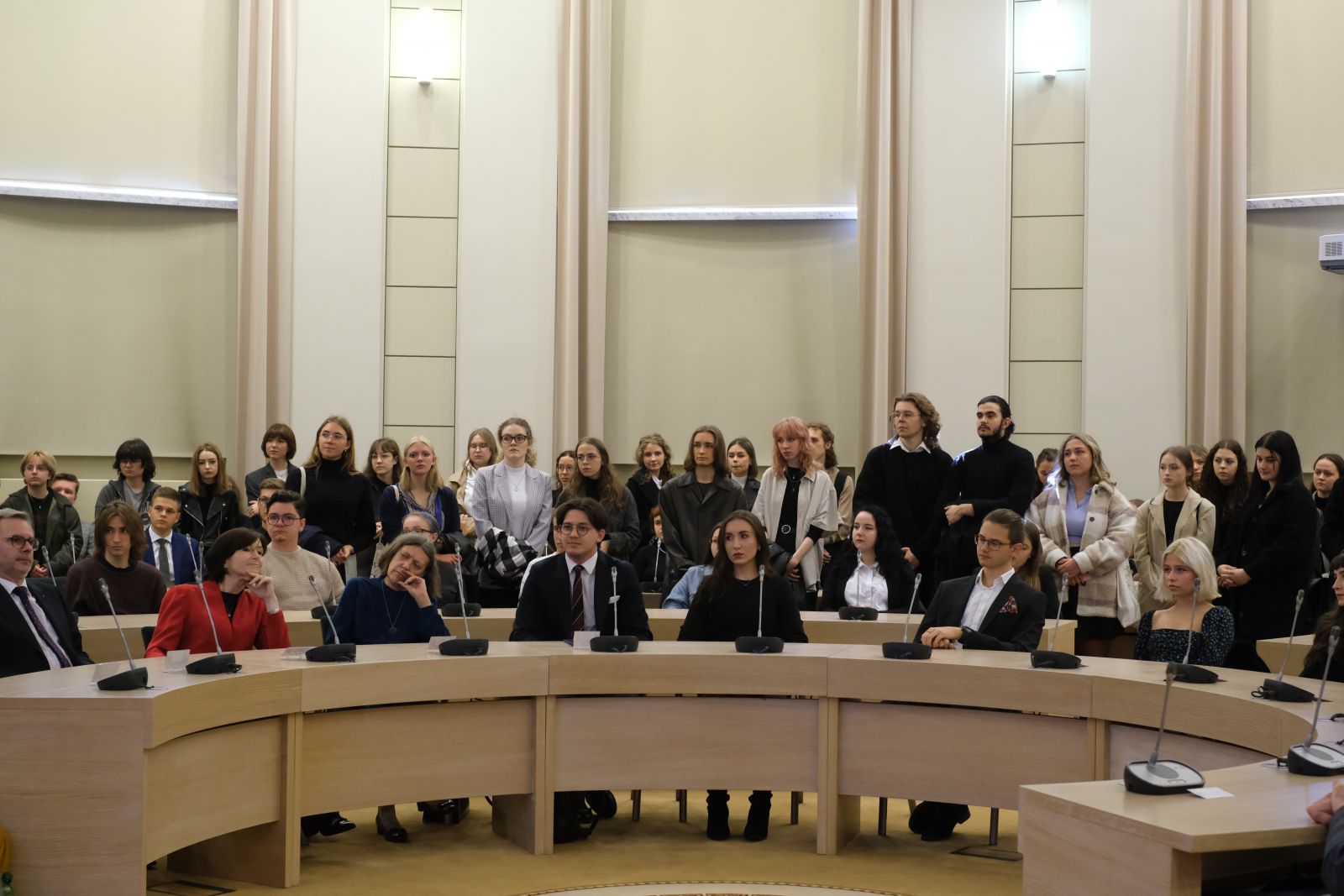 Licznie zgromadzeni studenci I roku siedzą i stoją w Salonie Mickiewicza.