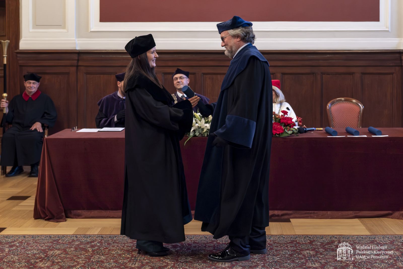 Promotor wręcza doktorantce dyplom.