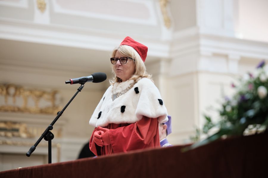 JM Rektor UAM przemawia do mikrofonu za stołem prezydialnym.
