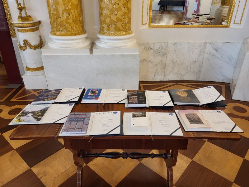 Na stole wyłożone są dyplomy i książki nagrodzone w Konkursie im. prof. Jerzego Skowronka.