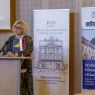 Prof. Ewa Szperlik przemawia przy mównicy, na pulpicie przed nią stoją małe flagi Polski i Bośni i Hercegowiny, za nią dwa roll-upy: Polskiej Akademii Nauk Oddziału w Poznaniu i wydziałowy.