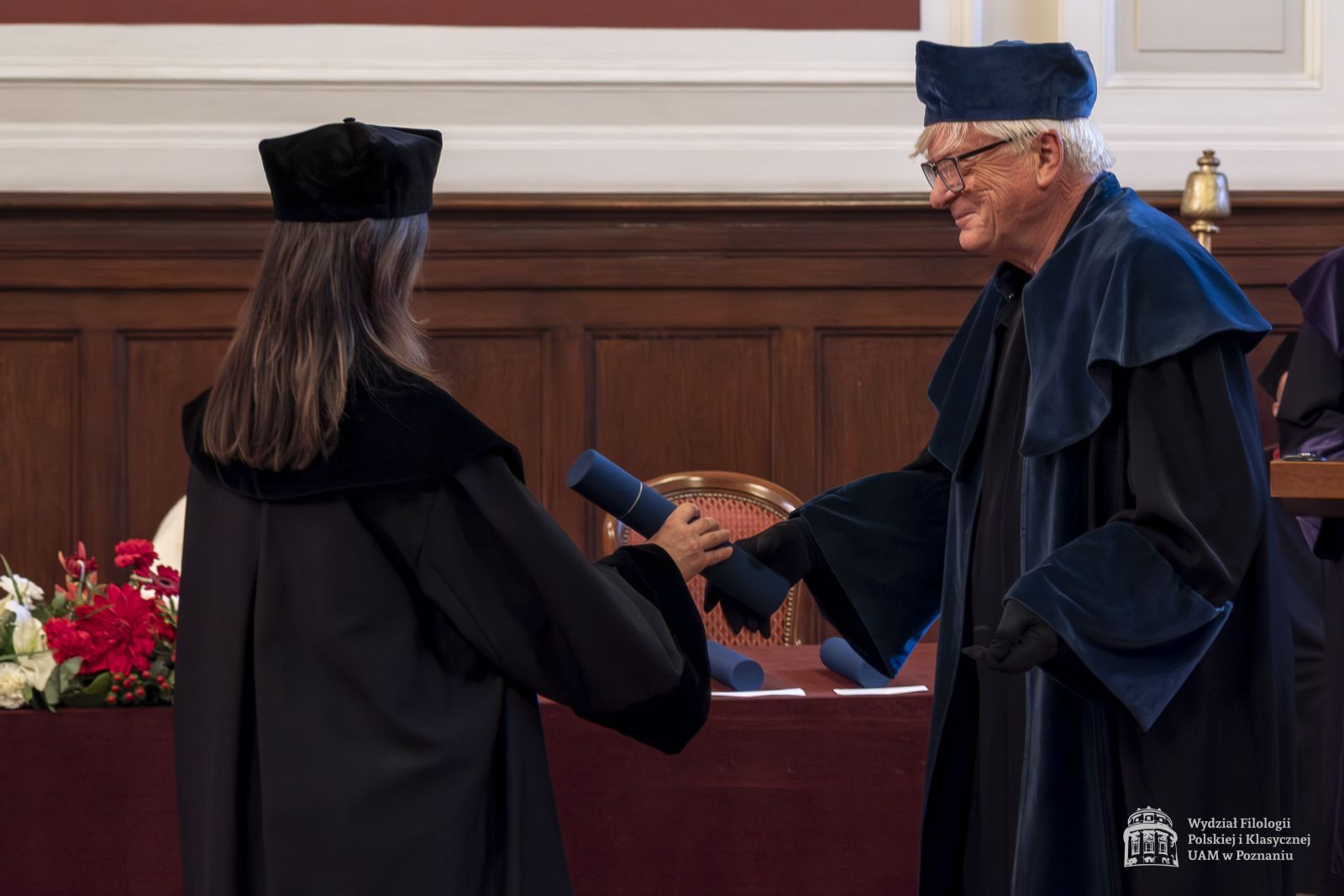 Promotor wręcza doktorantce dyplom.